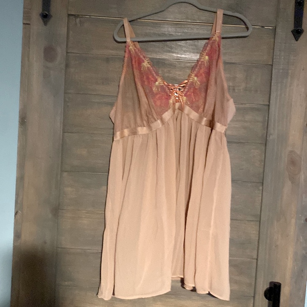 Peach colored baby doll with bright embroidered flowers